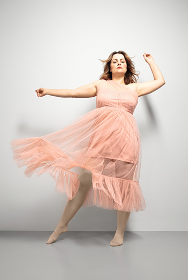 1. Lifestyle image Juzo Inspiration Woman with Juzo Inspiration and tights in almond and pink dress
