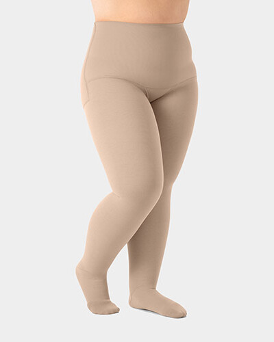 Jambe d'une personne portant des collants de compression Juzo Expert et se tenant légèrement de profil.