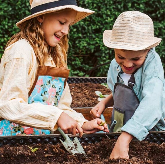 Auf kleine Kinder sollte man im Garten besonders achten Oma und Enkeltochter sitzen im Garten