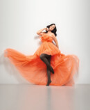 Lifestyle image Juzo Inspiration Woman with Juzo Inspiration and tights in cocoa and orange dress