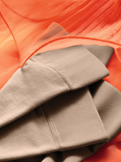 Juzo Inspiration Strümpfe liegen auf einem Orangenen Tüllkleid