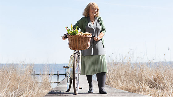 A woman on a jetty is wearing compression stockings