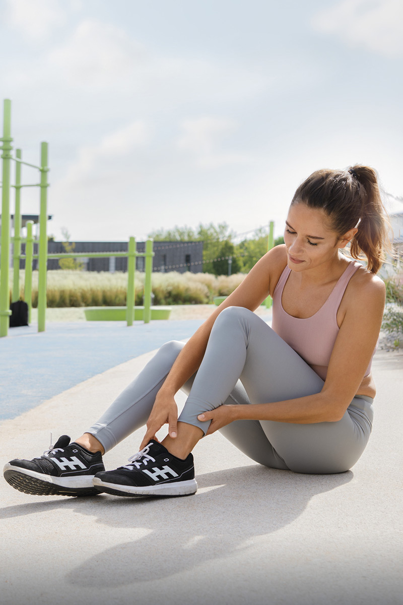 Pain in the ankle joint Woman is holding her ankle because of pain