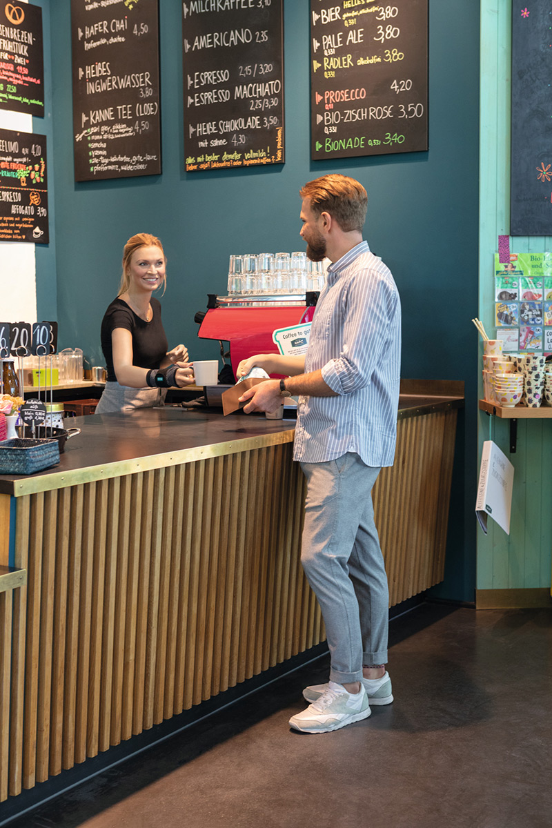Kellnerin in einem Cafe trägt eine Handgelenkbandage